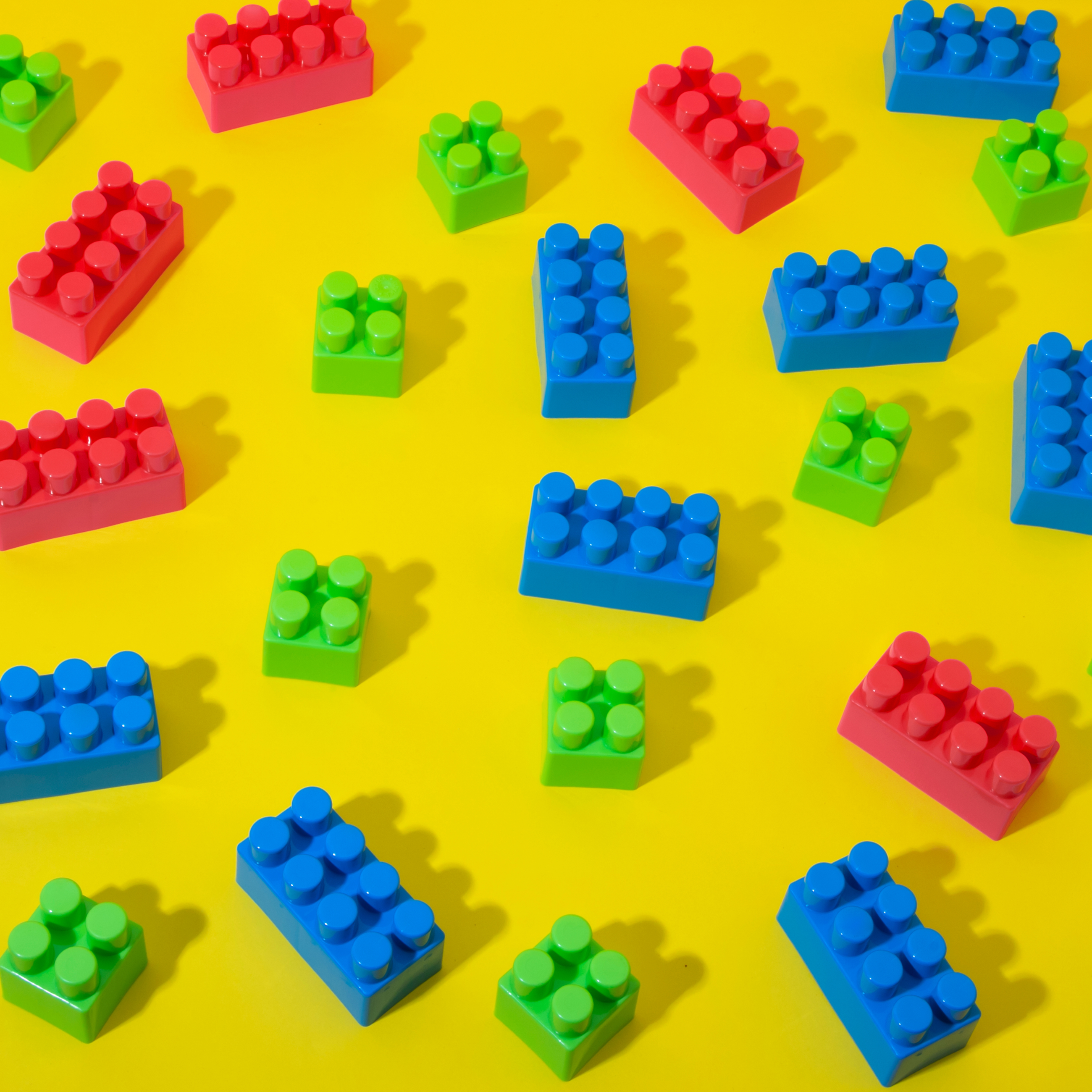 Red, green, and blue lego on a yellow background